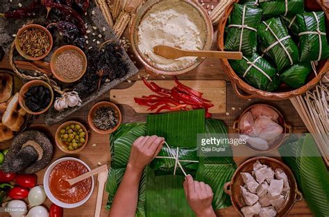 Woman's hands tying Guatemalan tamales, with many ingredients on a ...