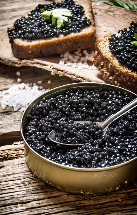 Sandwiches with black caviar, a jar of caviar and spoon. Stock Photo by Artem_ka