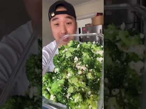 a man holding a container full of broccoli