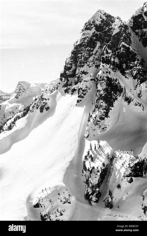 Vertical shot of a snowy mountain with a clear sky in the background in ...