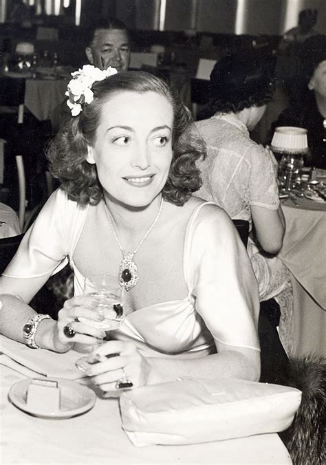 an old black and white photo of a woman sitting at a table in a restaurant