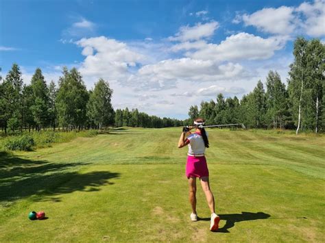 Premium Photo | Female golfer swings golf club on golf course