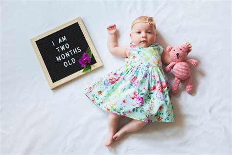 Cute One Month Old Baby Girl in Trendy Outfit Laying between Letter ...