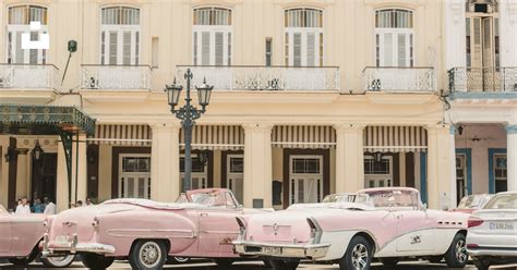 Pink and white chevrolet camaro parked in front of beige concrete ...