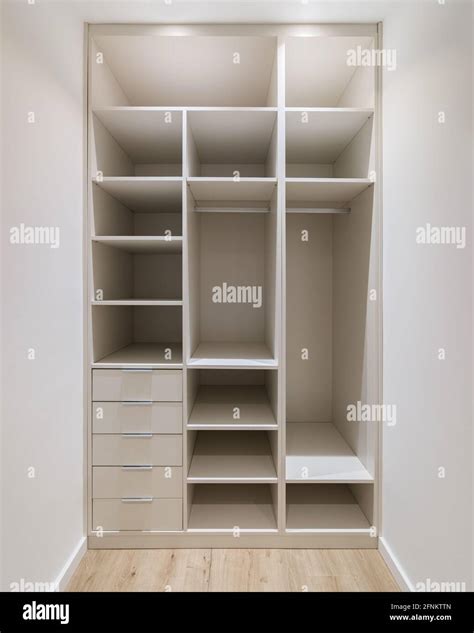 New built-in furniture in a small dressing room. Modern storage room with wardrobe, many shelves ...