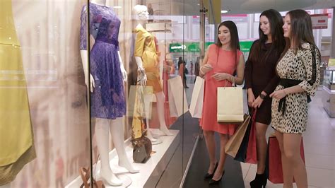 Three nice shopping women in shopping center discussing the clothes in shop-window Stock Video ...