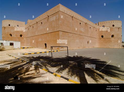 Al Hazm Castle behind the shadows of two palm trees, Al Hazm, Al Batinah, Oman Stock Photo - Alamy