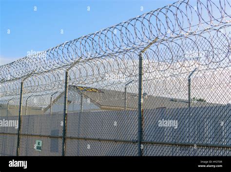 Prison fence barbed wire protects the community Stock Photo - Alamy