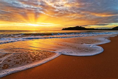 Golden swash - Sunrise on Clifton Beach in Northern Queensland ...