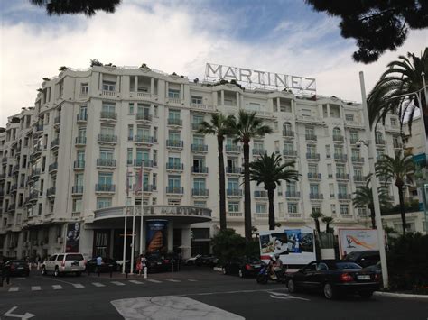 the marquee hotel is located in front of palm trees and parked cars on the street