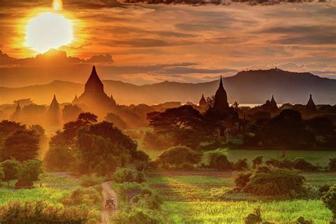 Sunset over Bagan Temples and green fields in Myanmar Photograph by ...