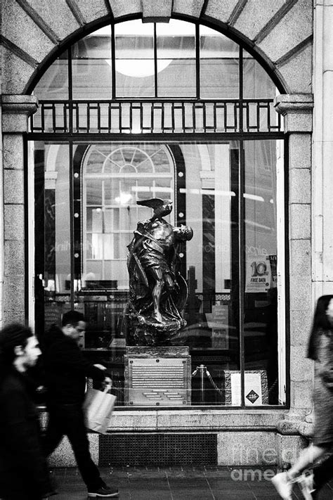 people walking past the cuchulainn statue in the window of the gpo ...