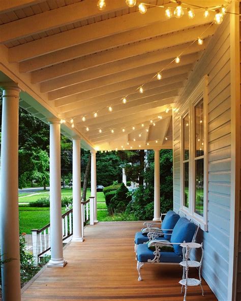 Restored Victorian wrap around porch... string cafe lights and vintage patio cast iron furniture ...