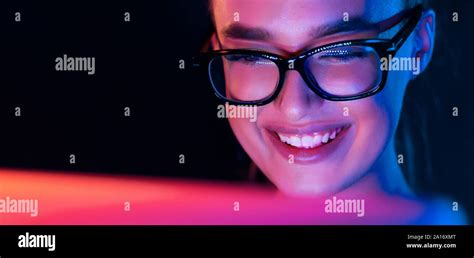 Happy girl looking at laptop screen at night Stock Photo - Alamy