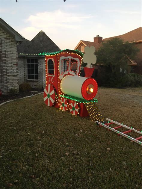 a train decorated with christmas lights and candy canes in front of a ...