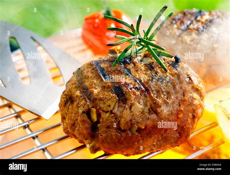 Hamburger patty grilling on the barbecue isolated on Stock Photo - Alamy