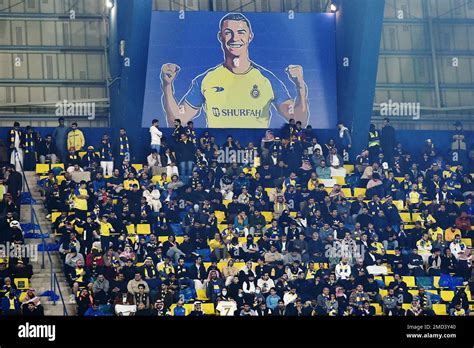 Al Nassr fans sit under a giant billboard of Cristiano Ronaldo during ...