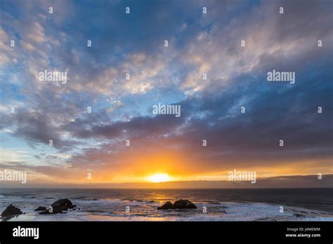 Rocks in ocean at sunset Stock Photo - Alamy