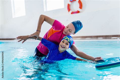 Boy having a swimming lesson with instructor Stock Photo | Adobe Stock