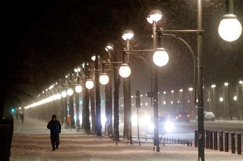 People walk on the snow covered boulevard 'Strasse des 17. Juni' in central Berlin, Germany ...