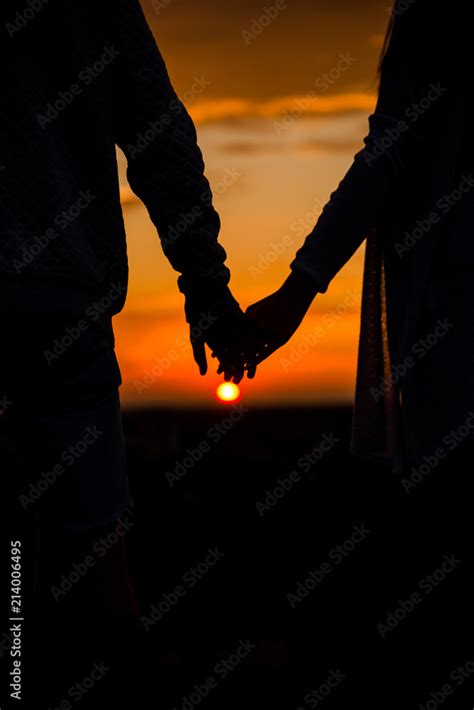 Couples In The Sunset Holding Hands