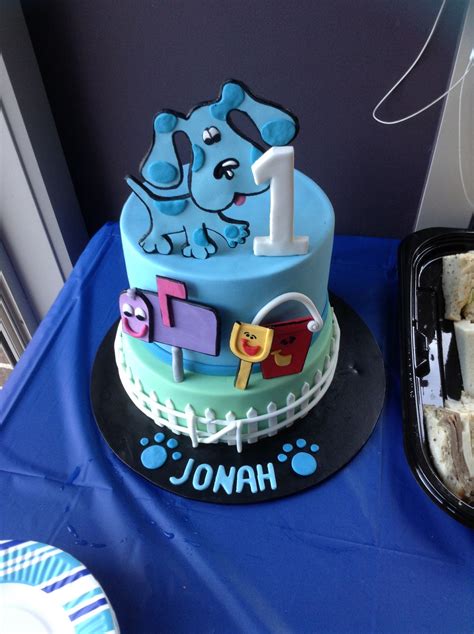 a blue and black birthday cake with an elephant on top