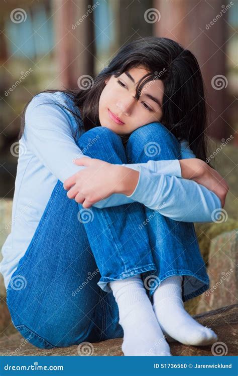 Sad Teen Girl Sitting On Rocks Along Lake Shore, Lonely Expression Stock Photo | CartoonDealer ...