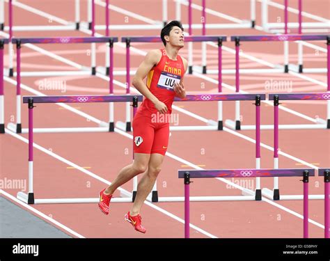 China's Liu Xiang hops down the track after hitting the first hurdle and injuring himself whilst ...