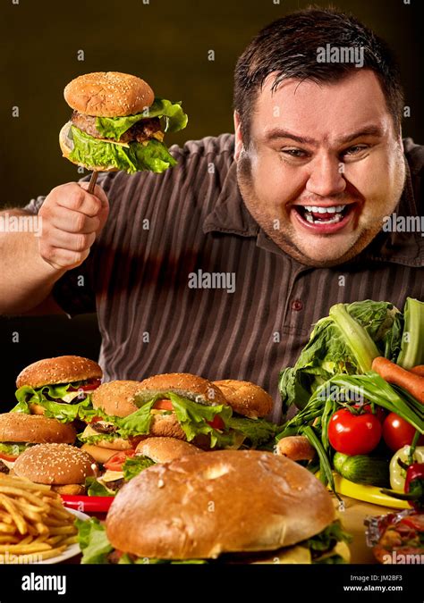 Diet fat man makes choice between healthy and unhealthy food Stock Photo: 150029015 - Alamy