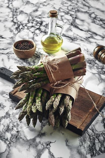 Premium Photo | An edible raw stems of asparagus on a marble background