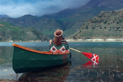 Girl canoeing on a mountain lake | Nature Stock Photos ~ Creative Market