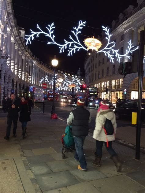 two people walking down the street in front of some buildings with ...