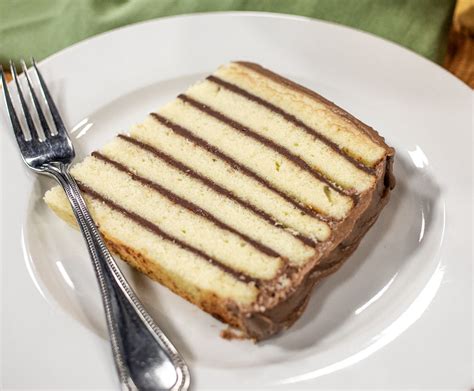 a piece of cake sitting on top of a white plate next to a knife and fork