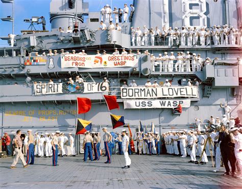 Crewmen of the aircraft carrier USS Wasp (CV-18) gather on deck to watch the recovery of the ...