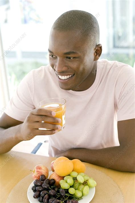 Man drinking orange juice - Stock Image - F001/2488 - Science Photo Library