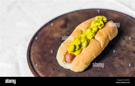 Traditional hot dog with gherkin and mustard relish against white background Stock Photo - Alamy