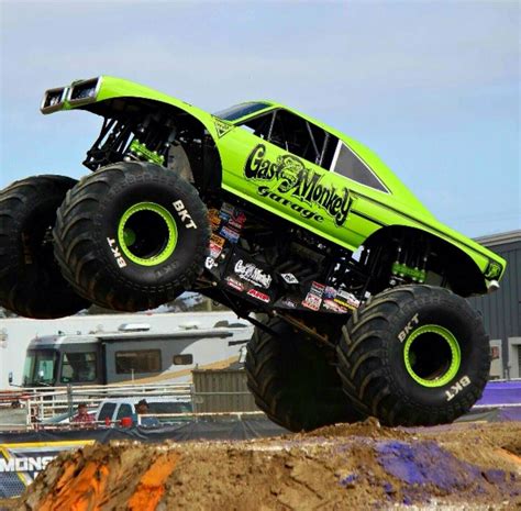 a monster truck is in mid air above the ground, with it's front wheels up