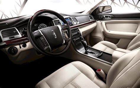 the interior of a car with beige leather and black trims, including steering wheel