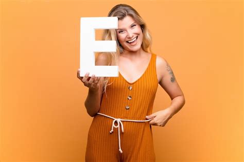 Premium Photo | Excited, happy, joyful, holding the letter E of the alphabet to form a word or a ...