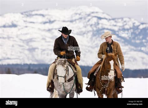 Cowboys riding horses in snow hi-res stock photography and images - Alamy