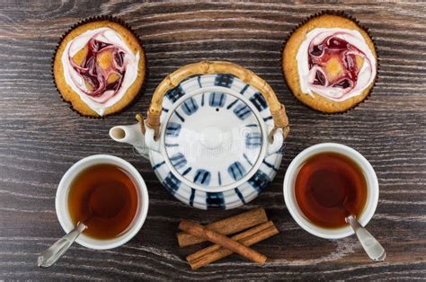 Cakes, Cups of Tea, Cinnamon Sticks and Teapot on Table Stock Photo - Image of meal, table: 84514646