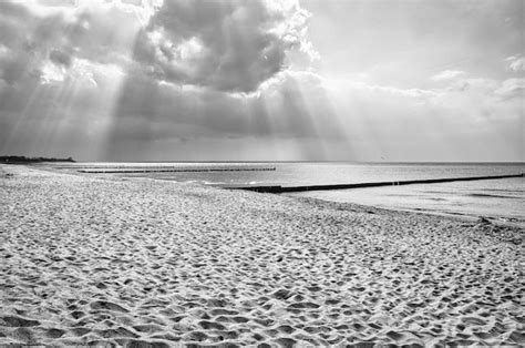 Premium Photo | Sun rays shining through dense clouds on the beach of ...