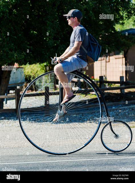 Man riding a penny-farthing, high wheel, high wheeler, or ordinary bicycle Stock Photo - Alamy