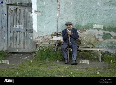 old man sitting on a bench, Viscri Stock Photo - Alamy