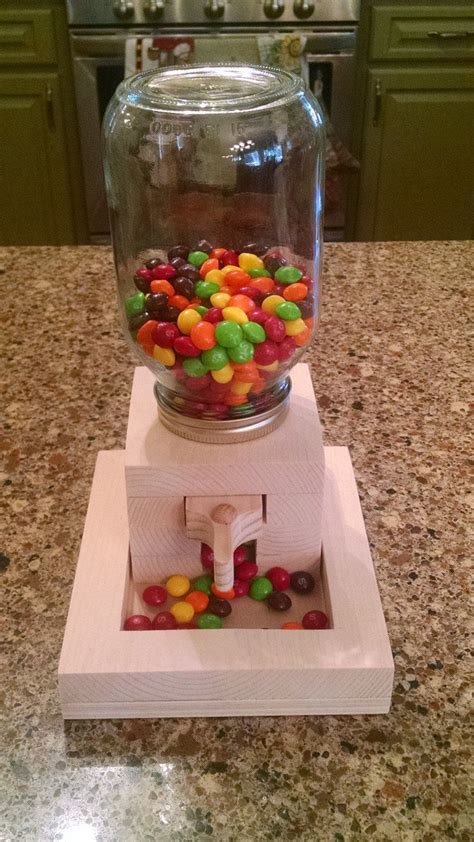 a candy dispenser on top of a counter with lots of candies in it