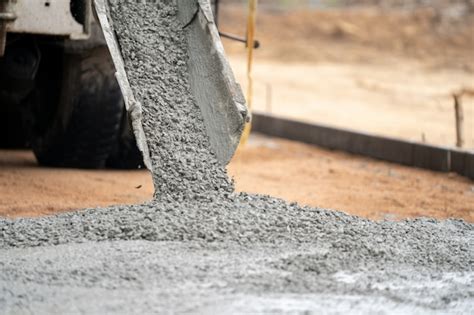 Premium Photo | A construction worker pouring a wet concret at road ...