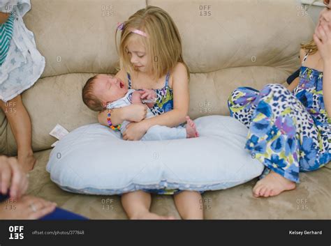 Little girl holding newborn baby stock photo - OFFSET