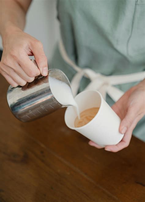 Unrecognizable coffee house professional pouring milk in coffee · Free Stock Photo