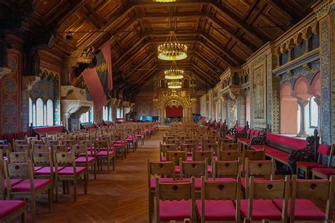 rows of wooden chairs are lined up in an ornately decorated room with ...