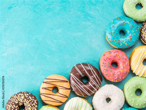 Top view of assorted donuts on blue concrete background with copy space. Colorful donuts ...